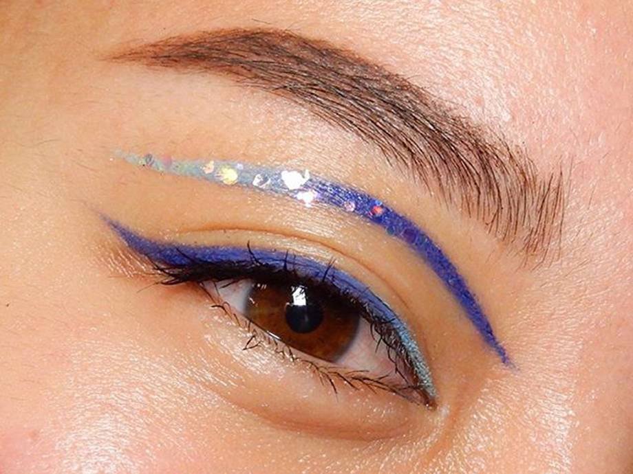 close-up of eye wearing blue glitter eye makeup and blue winged liner