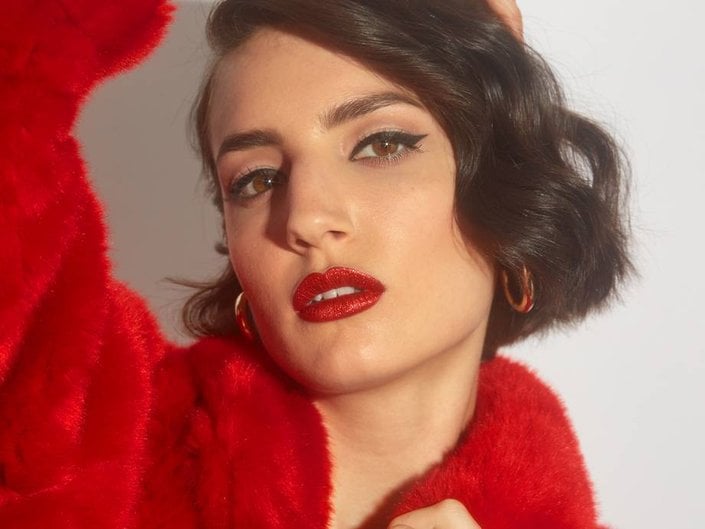 person wearing winged eyeliner and red glitter lipstick