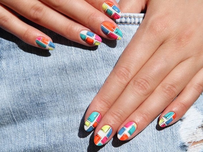 hands with multicolored nail art on nails