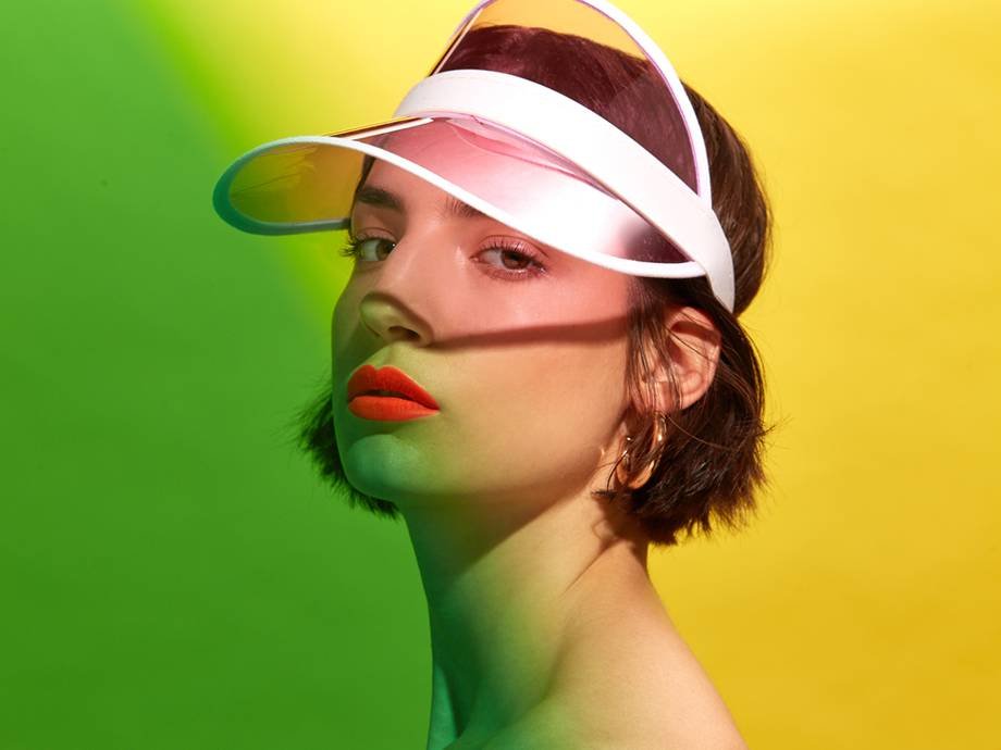 person wearing sun visor and neon orange lipstick