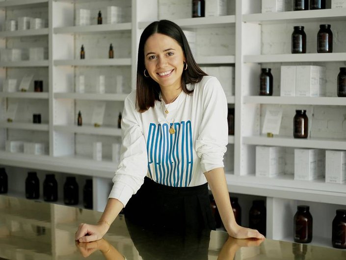 person leaning on desk and smiling at camera