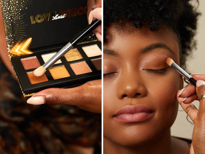 close up of eyeshadow palette and person applying makeup to someone's eyelid