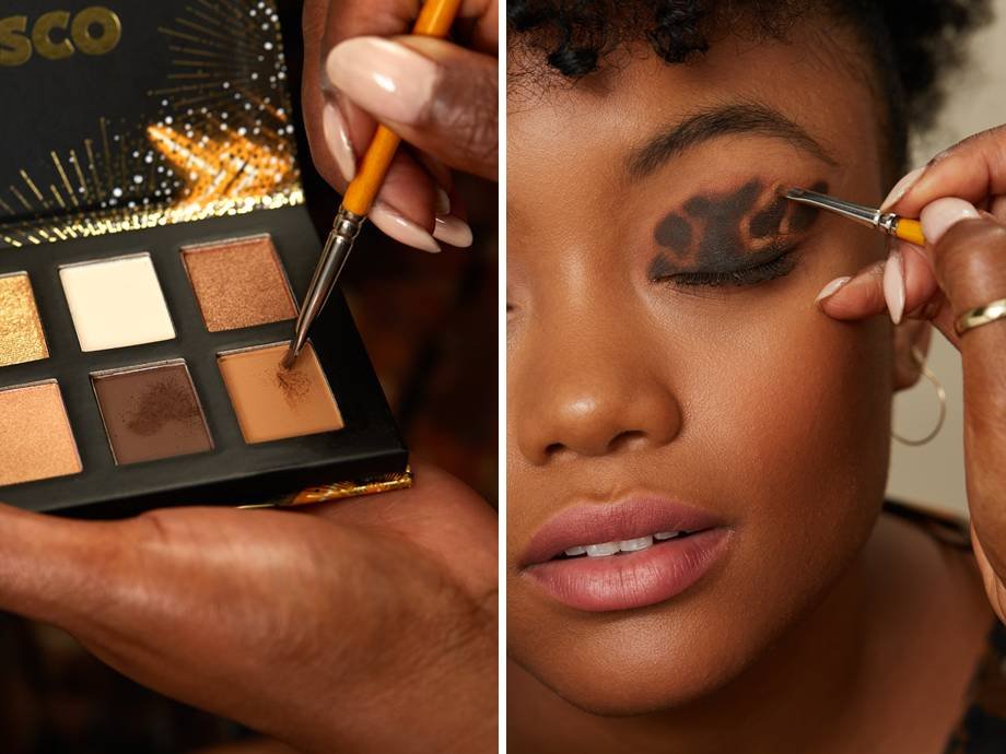 close up of eyeshadow palette and person applying makeup to someone's eyelid