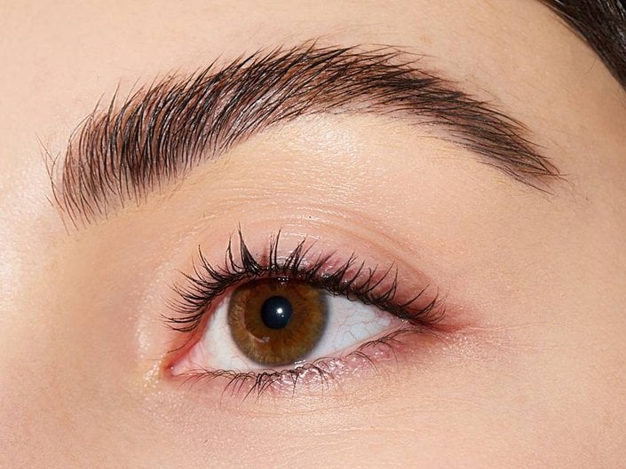 Close-up of a person’s eye with full, bushy eyebrows
