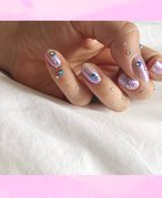hand with nails painted light purple with silver and blue rhinestone embellishments