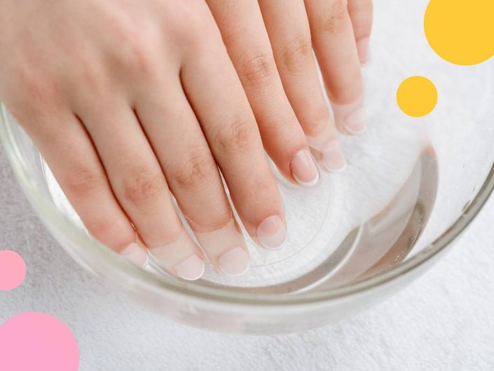 Image of a person's hands soaking in a bowl of clear liquid