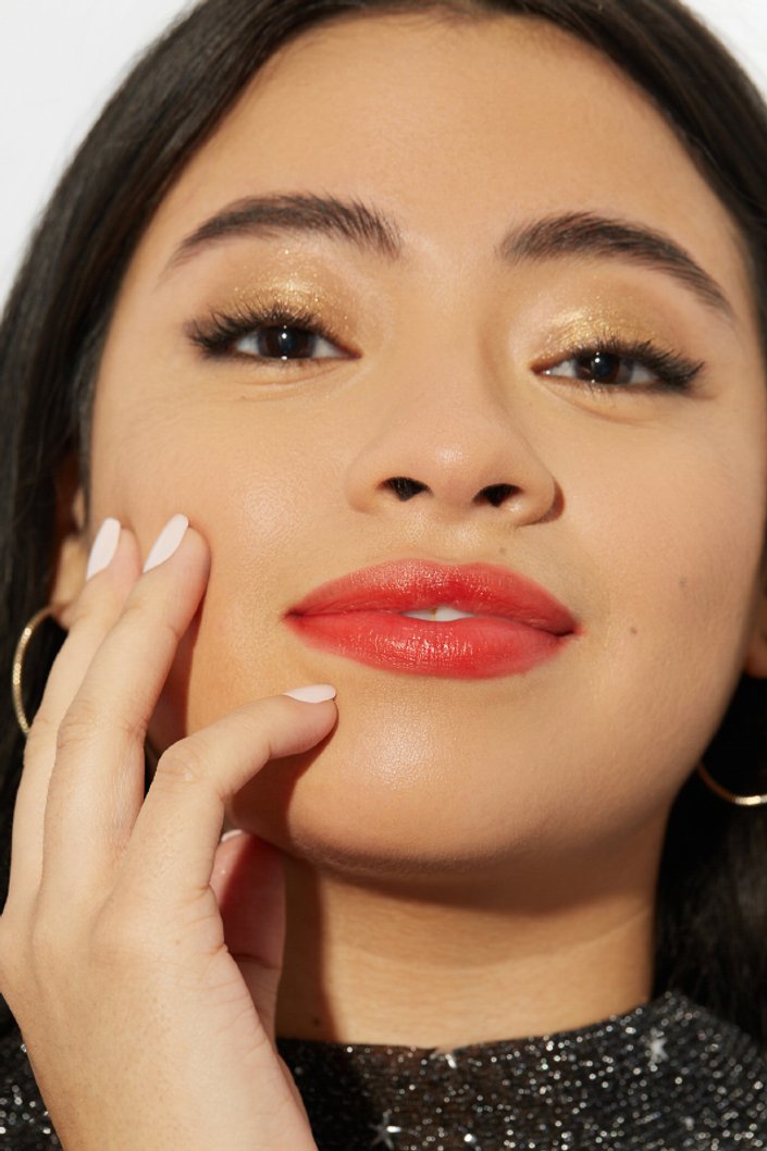 person wearing gold glitter eyeshadow and red lipstick
