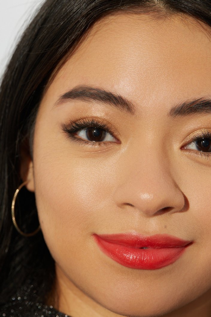 person wearing gold glitter eyeshadow and red lipstick