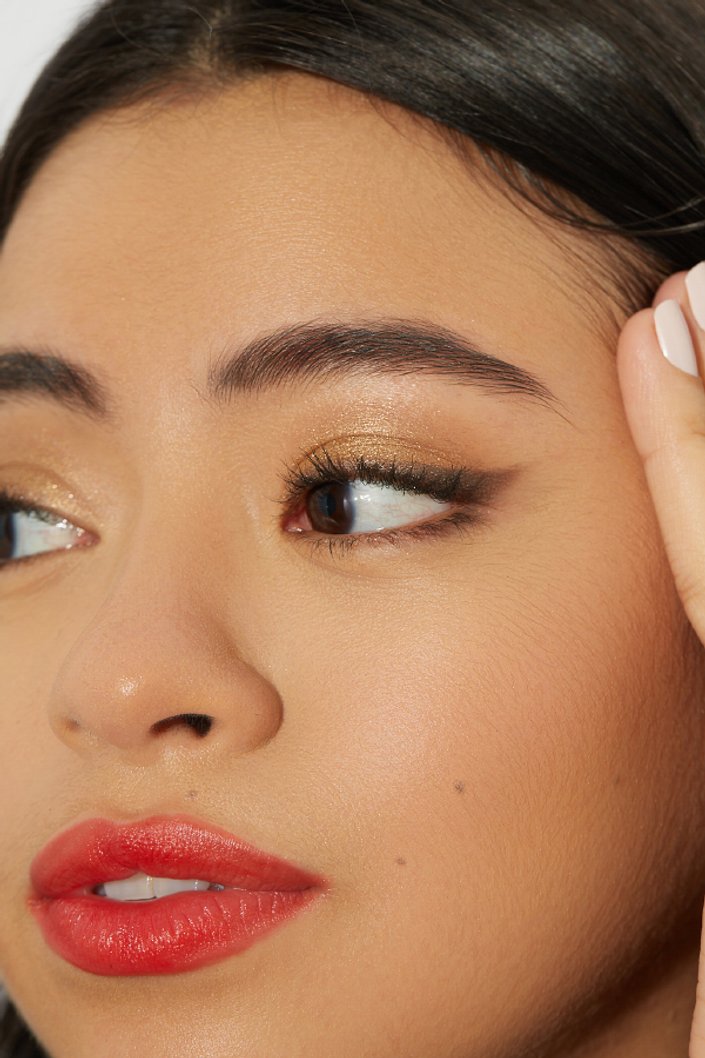 person wearing gold glitter eyeshadow and red lipstick