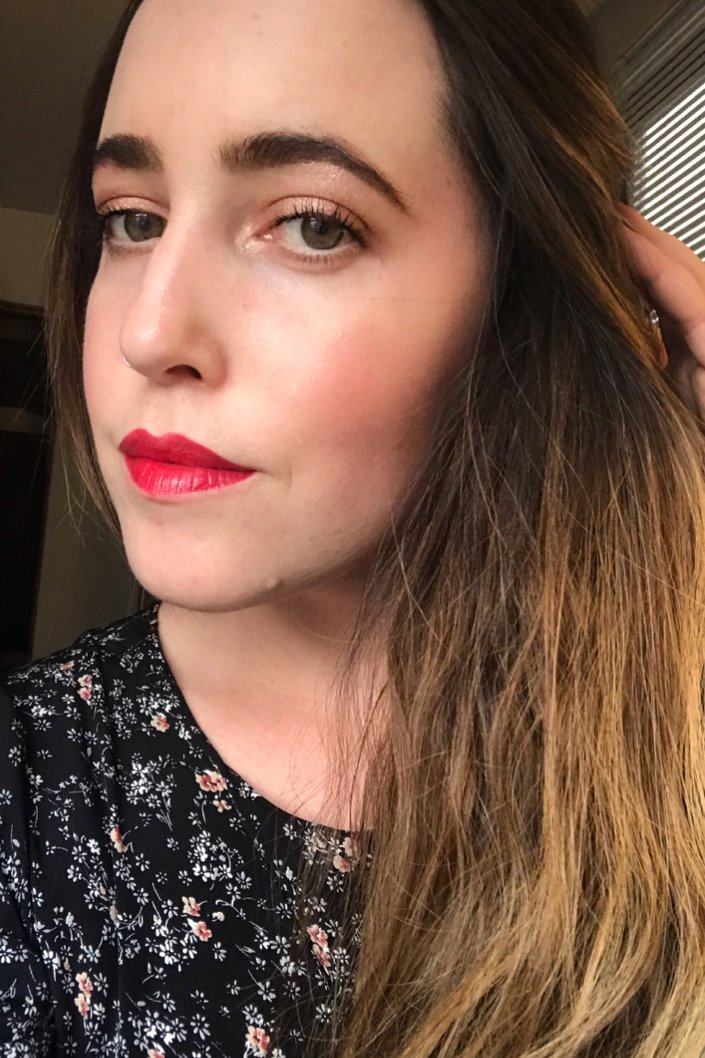 person wearing shimmery eye makeup and red lipstick