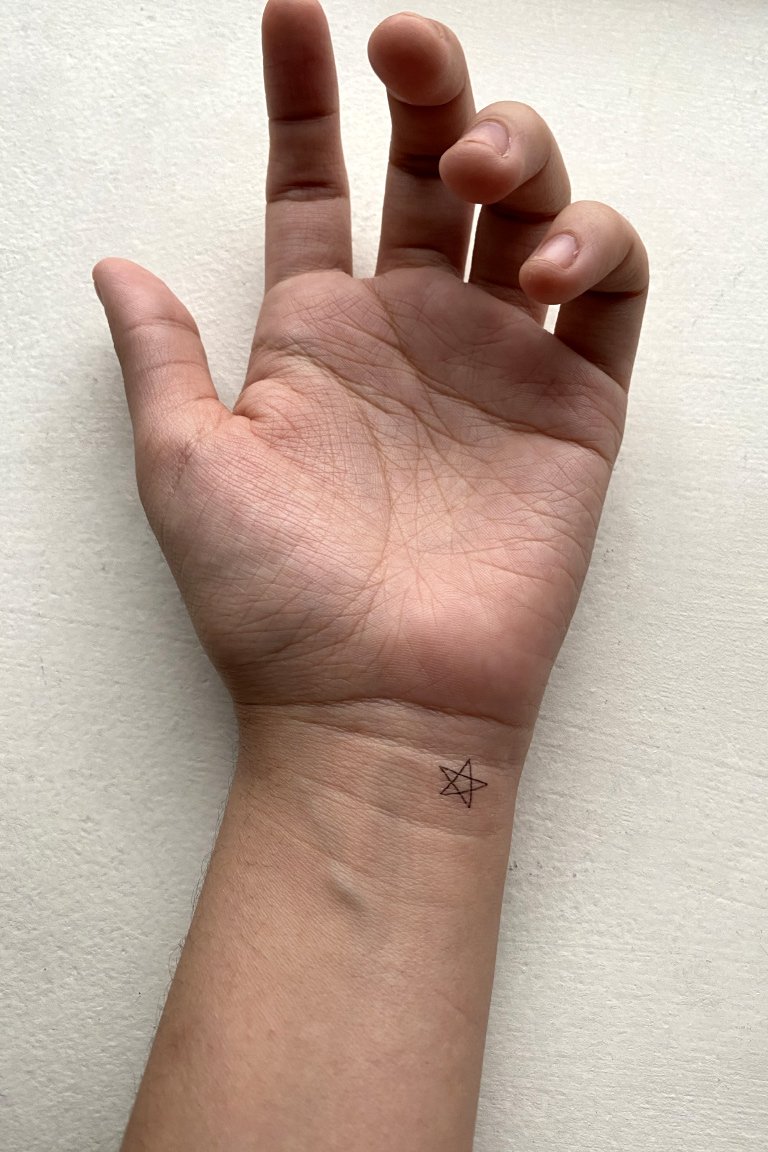 hand and arm with temporary tattoo on right side of wrist