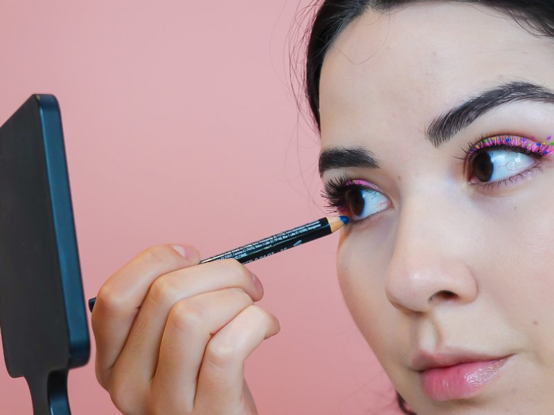 Image of a person applying pencil eyeliner to lower waterline