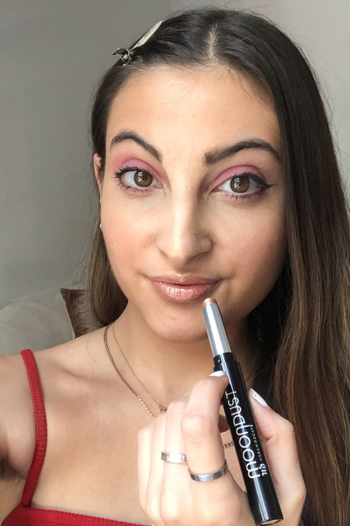 person applying urban decay moondust lip eclipse to lips