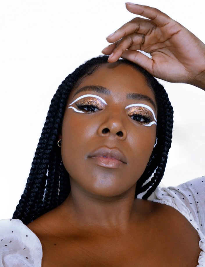 person wearing white winged eyeliner and gold glitter eyeshadow