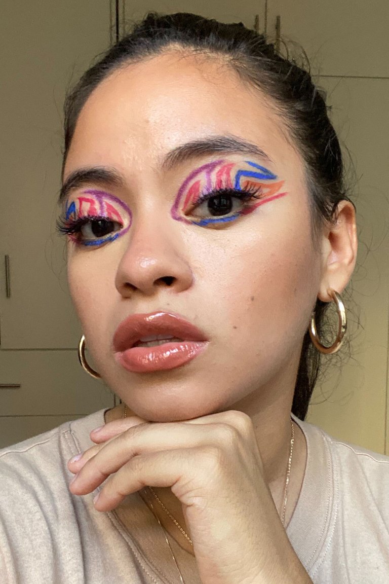 person wearing multicolored graphic eye makeup