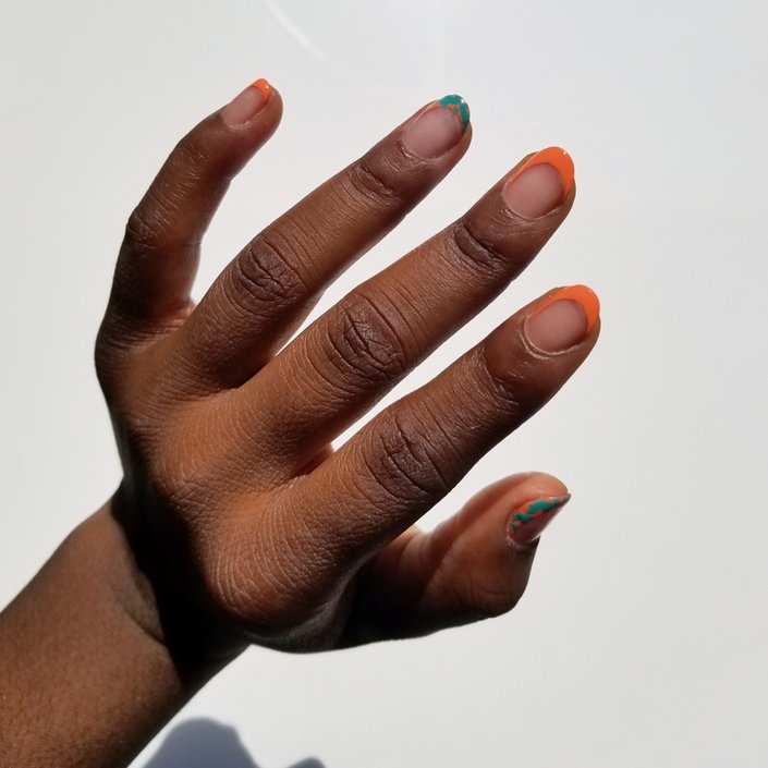 hand with orange and green french manicure nail art