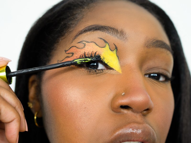 person applying mascara to eyelashes