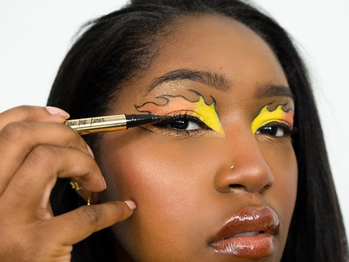person applying liquid eyeliner to upper lash line