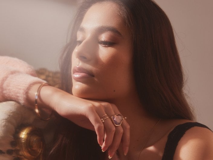 person looking off camera and posing with chin resting on hand