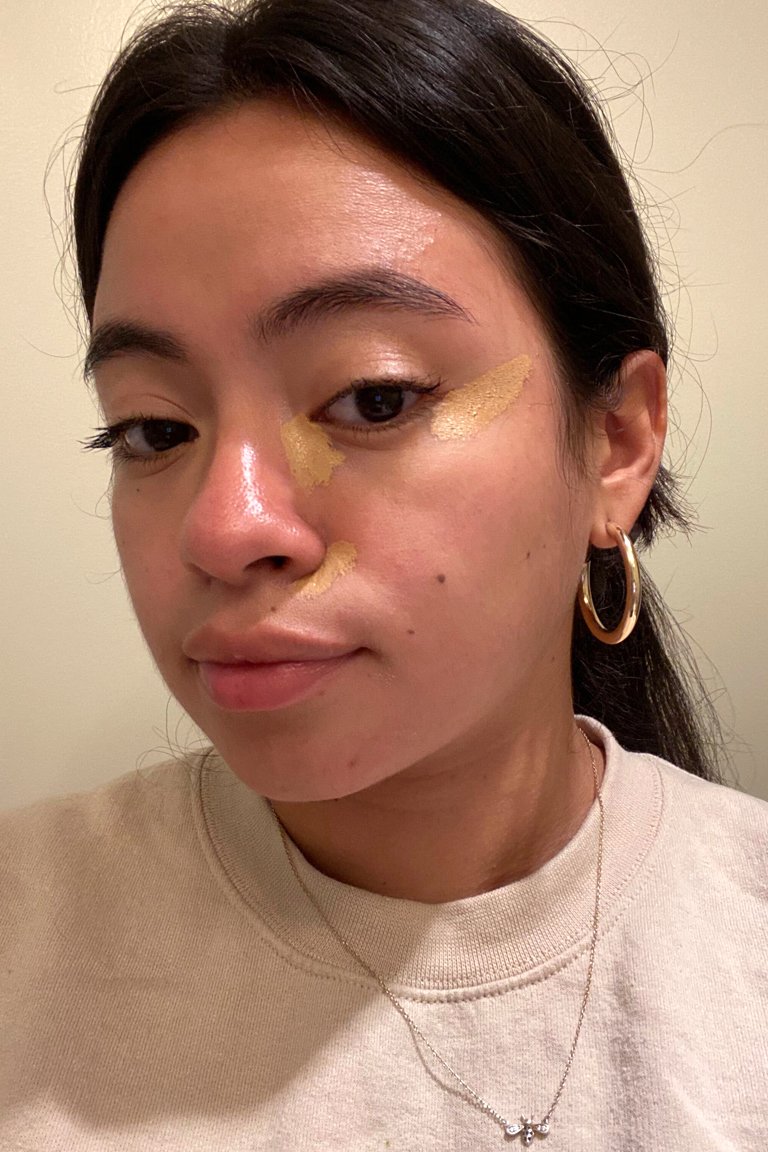 person with concealer swatches on face