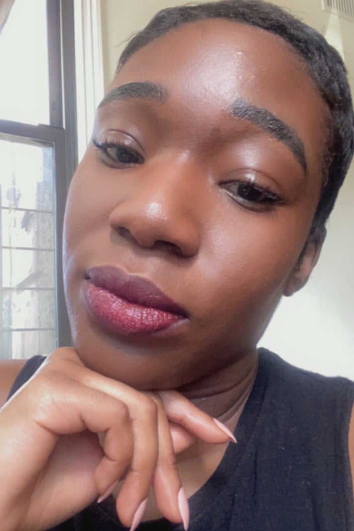 person with dark skin tone wearing berry lipstick
