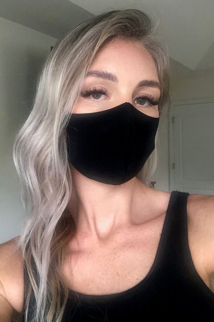 person wearing eyelash extensions with a protective face mask