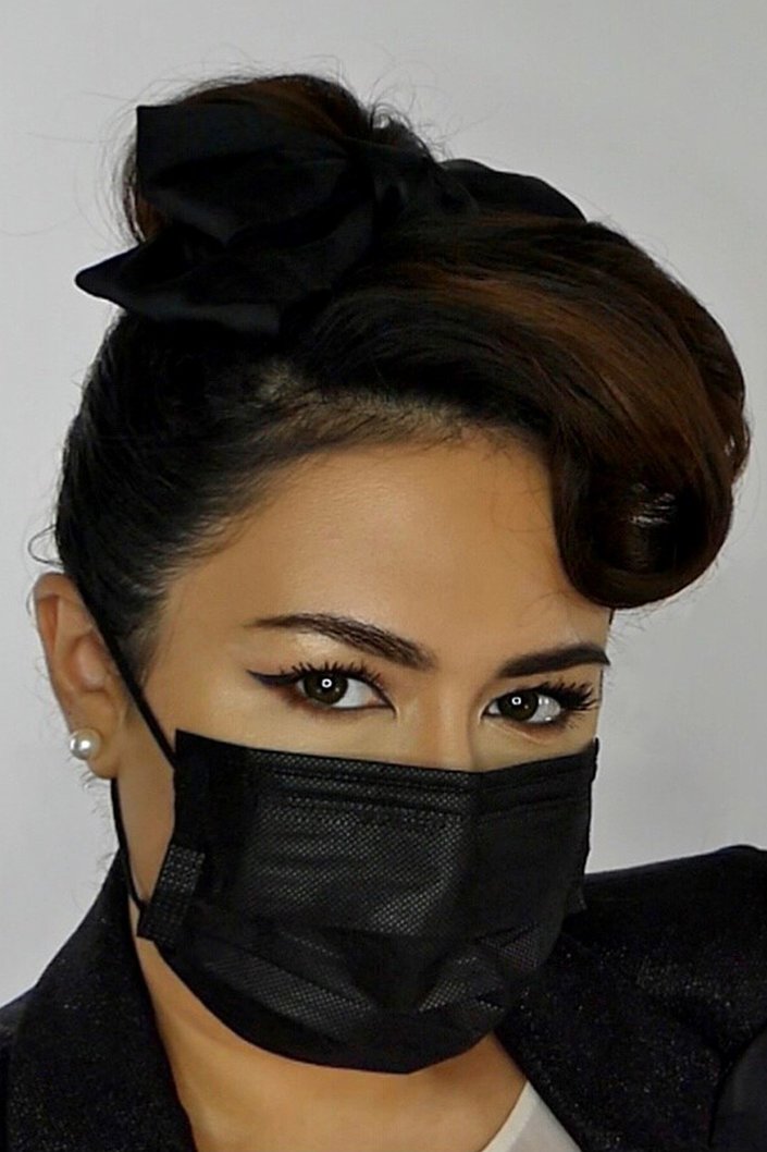 person wearing winged eyeliner with a protective face mask