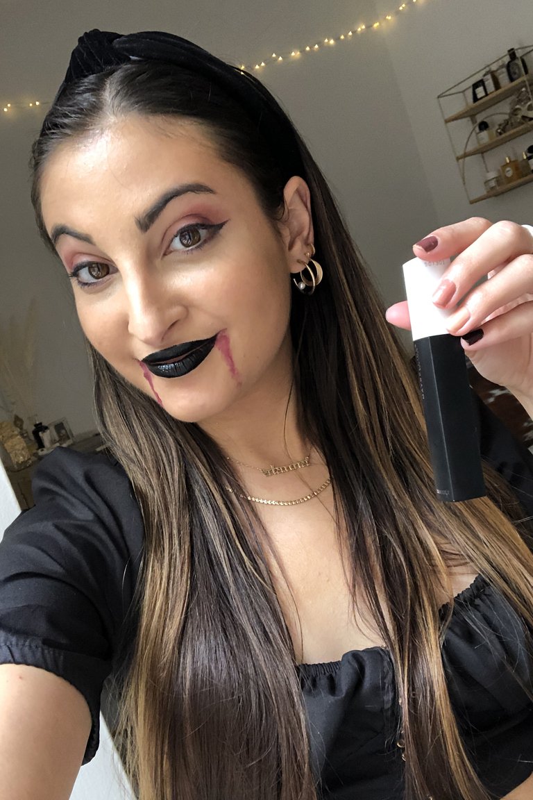 person wearing vampire face makeup and black lipstick