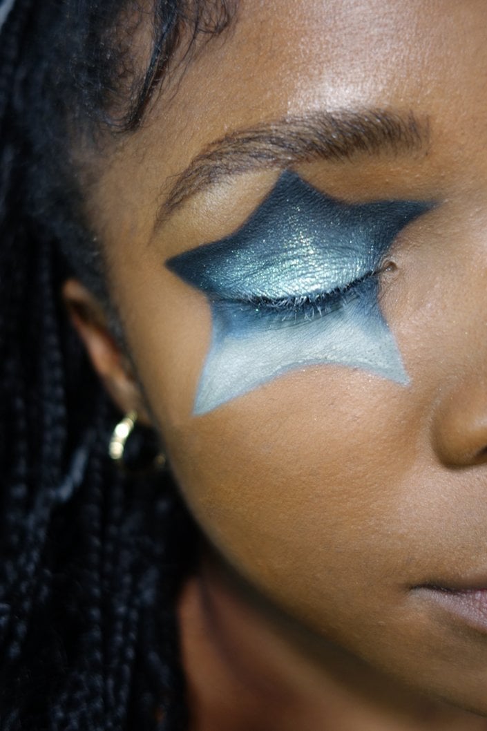person wearing blue glitter star-shaped eye makeup
