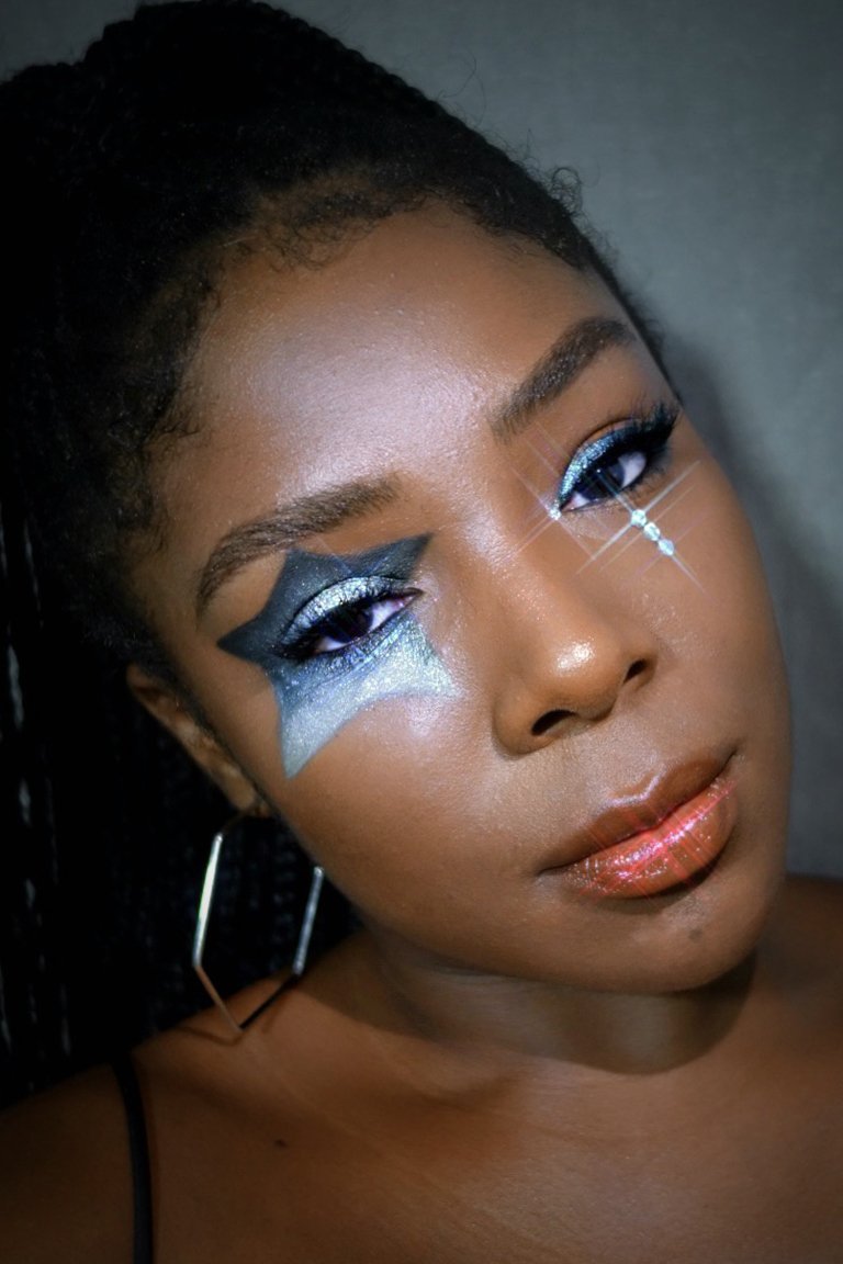 person wearing blue glitter star-shaped eye makeup