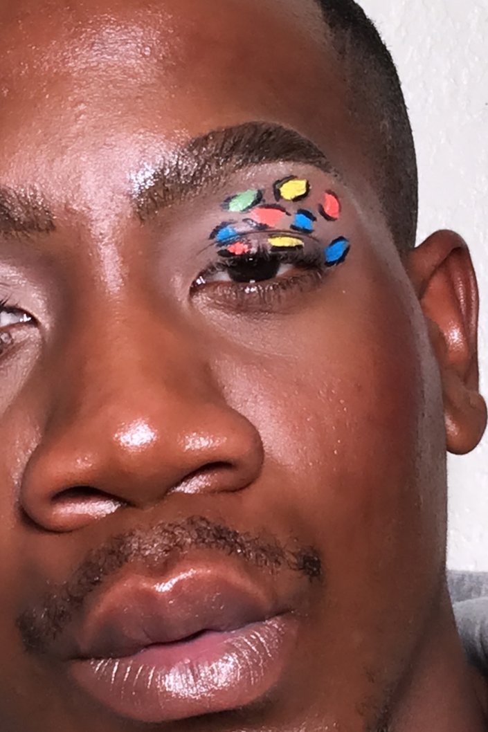 person wearing multicolored leopard-print eye makeup