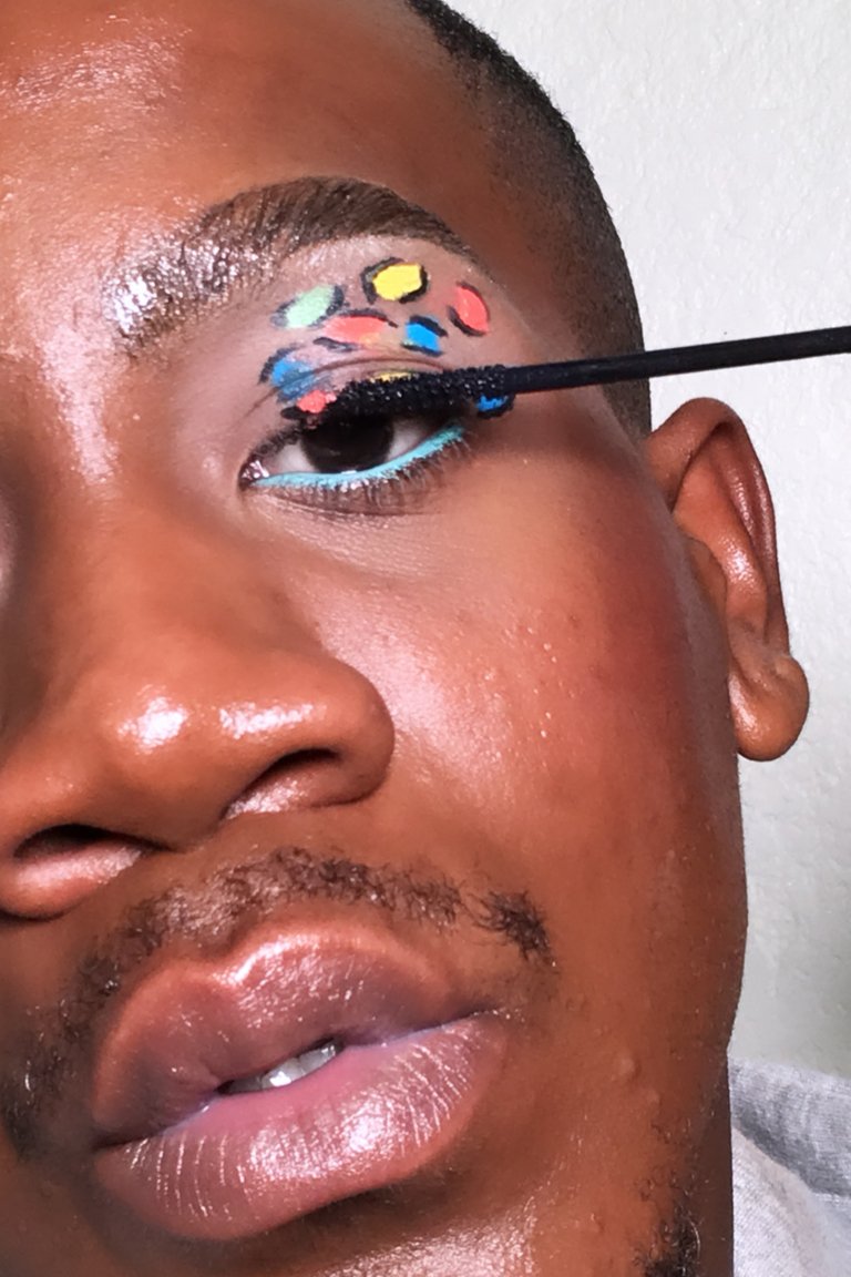 person adding mascara to eyelashes