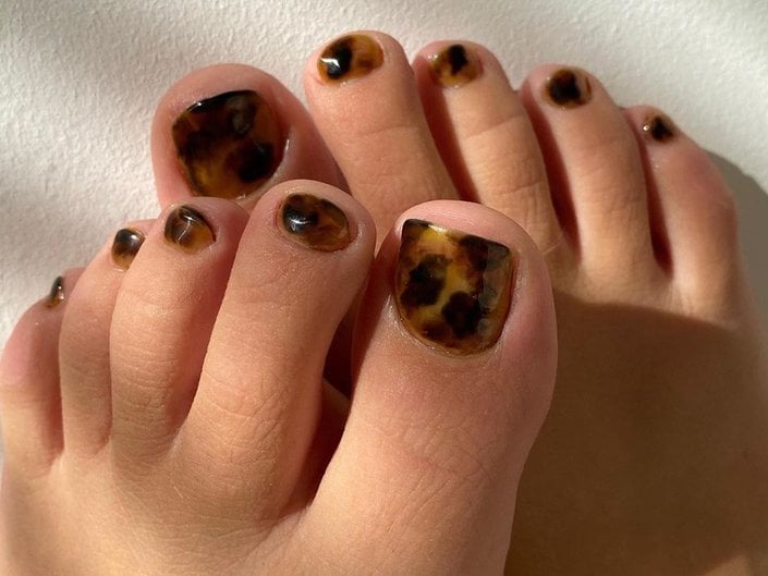 feet with tortoise nail art on toes