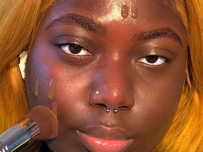 person applying foundation with a makeup brush