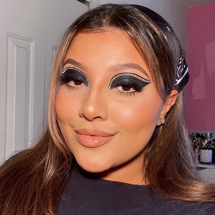 person wearing black eyeshadow with rhinestones