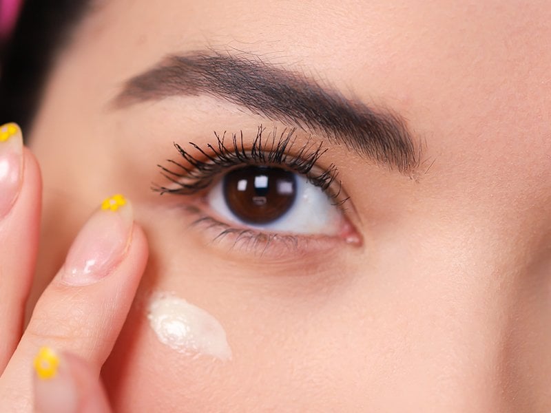 person applying moisturizer under eye