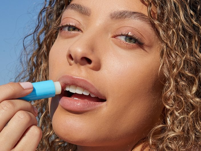person applying lip balm to lips
