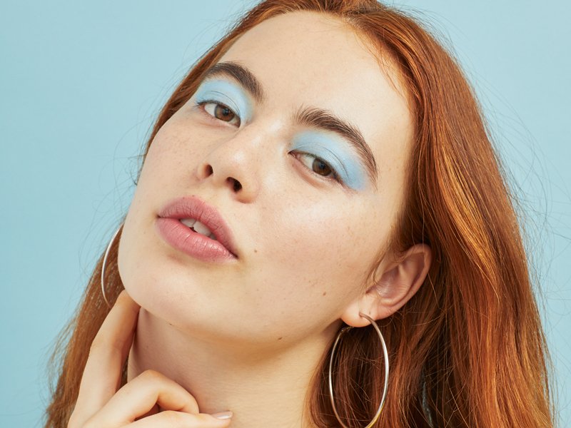 person with red hair wearing pastel blue eyeshadow