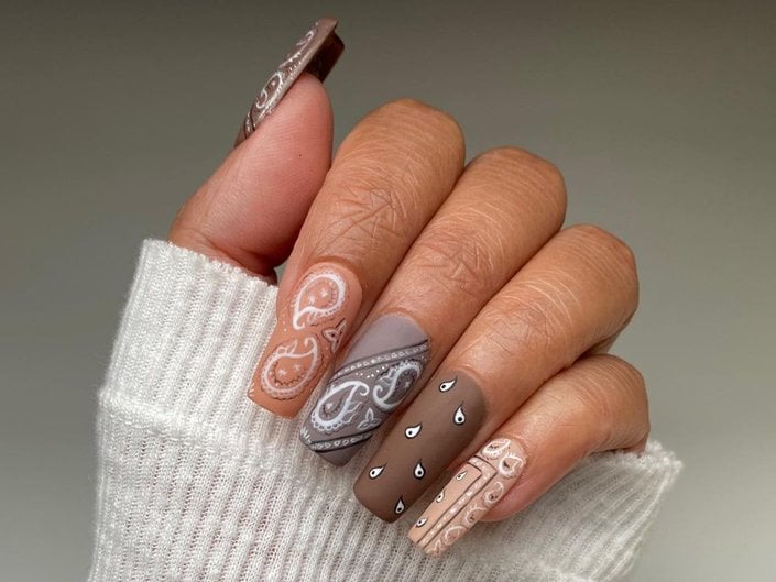 hand with brown bandana print on nails