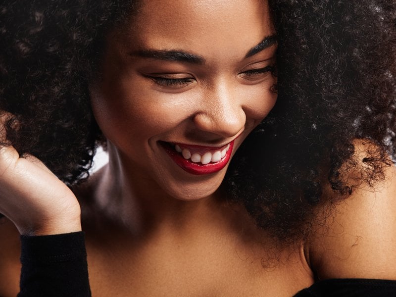 person with naturally curly hair wearing red lipstick