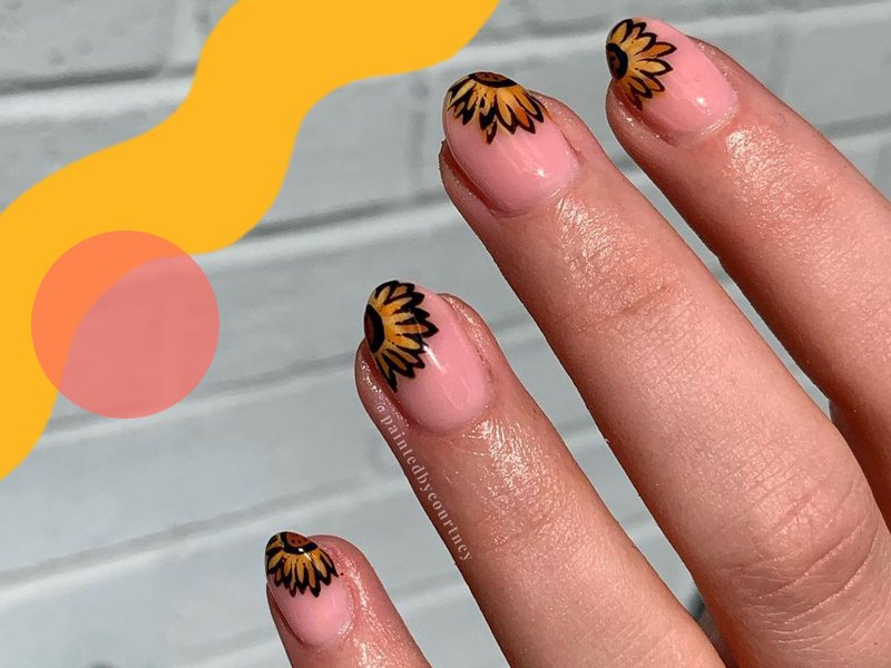 hand with sunflower nail art on nails