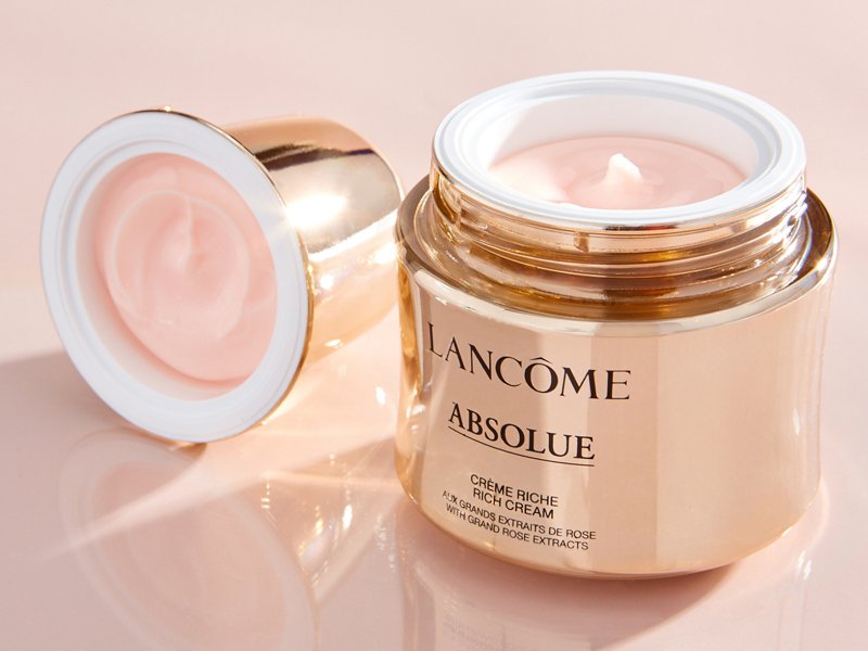 Close-up photo of the Lancôme Absolue Revitalizing & Brightening Soft Cream on a tabletop open with the cap next to it