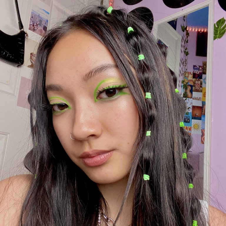 person wearing green graphic eye makeup