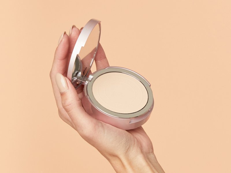 hand holding face powder compact