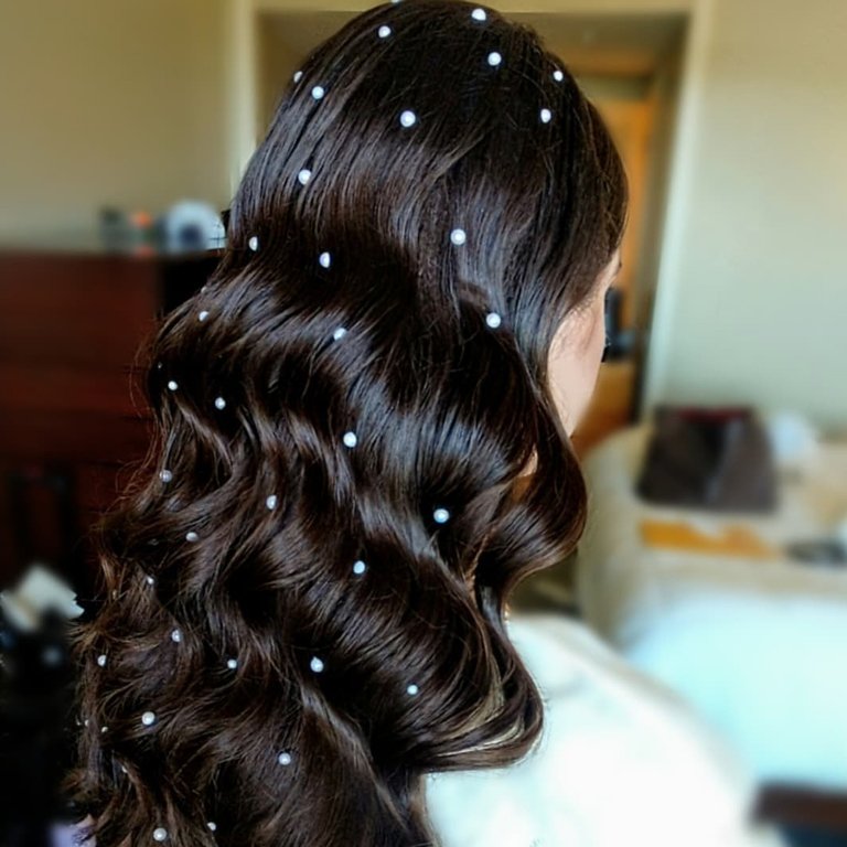 person with long wavy hair embellished with pearls