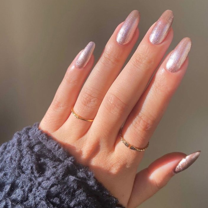 hand with holographic pink glitter nail polish on nails