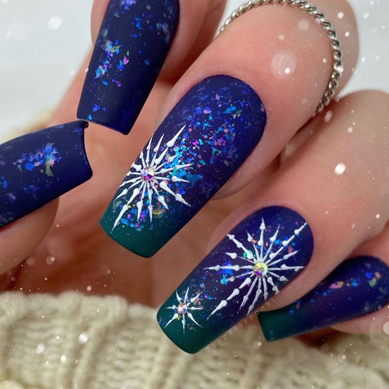 hand with snowflake nail art on nails