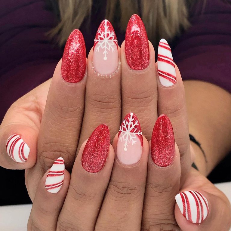 hands with snowflake and candy cane nail art on nails