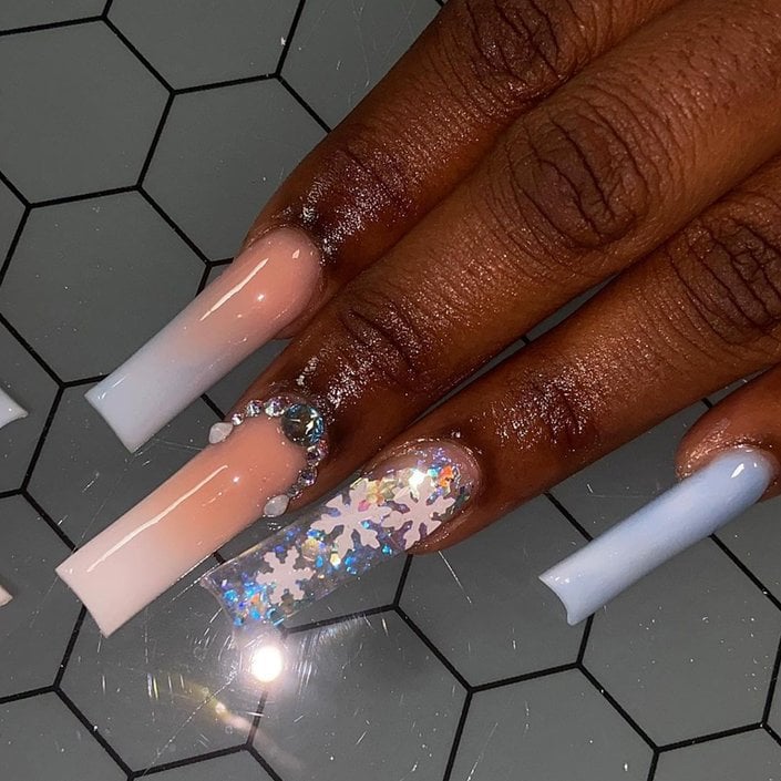 hand with snowflake nail art on nails