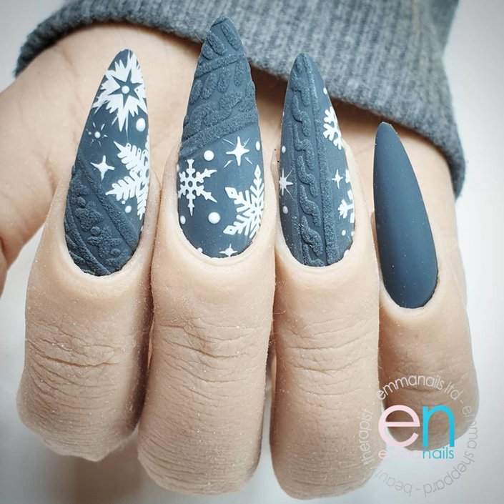 hand with snowflake nail art on nails